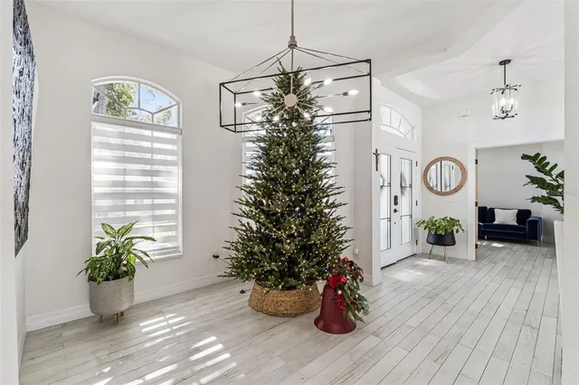 a living room with furniture kitchen view and a chandelier