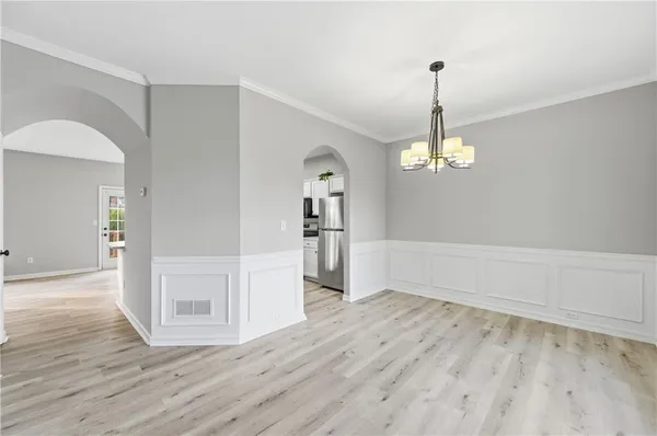 a large kitchen with stainless steel appliances a large counter top a sink a refrigerator and a window