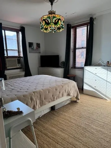 a bedroom with a bed and a dresser with mirror