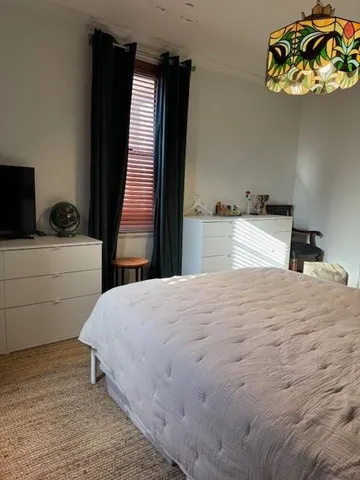 a bedroom with a bed and ceiling fan