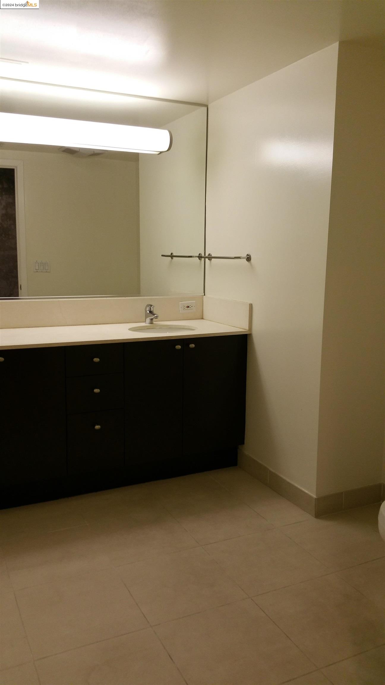 311 Oak Street, Unit 540 Oakland, CA 94607 - Photo 8 of 21 a room with a sink vanity and mirror