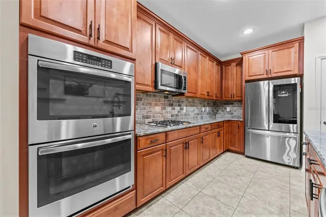 a kitchen with granite countertop stainless steel appliances and wooden cabinets
