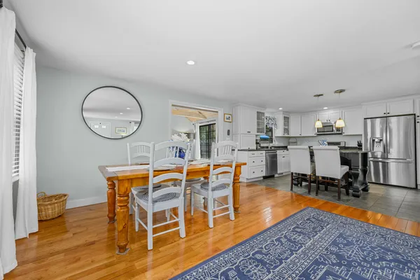 a kitchen with a table chairs microwave and cabinets