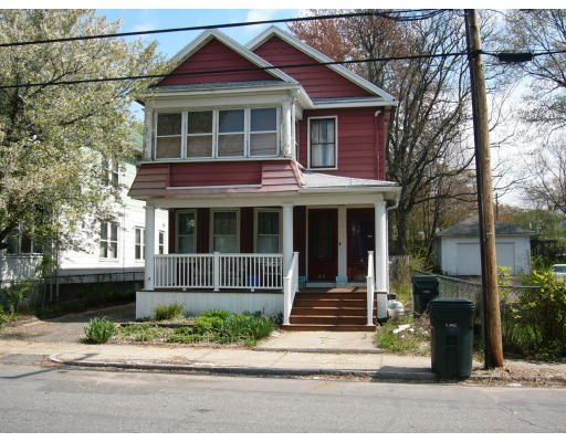 a view of a house with a yard and large tree