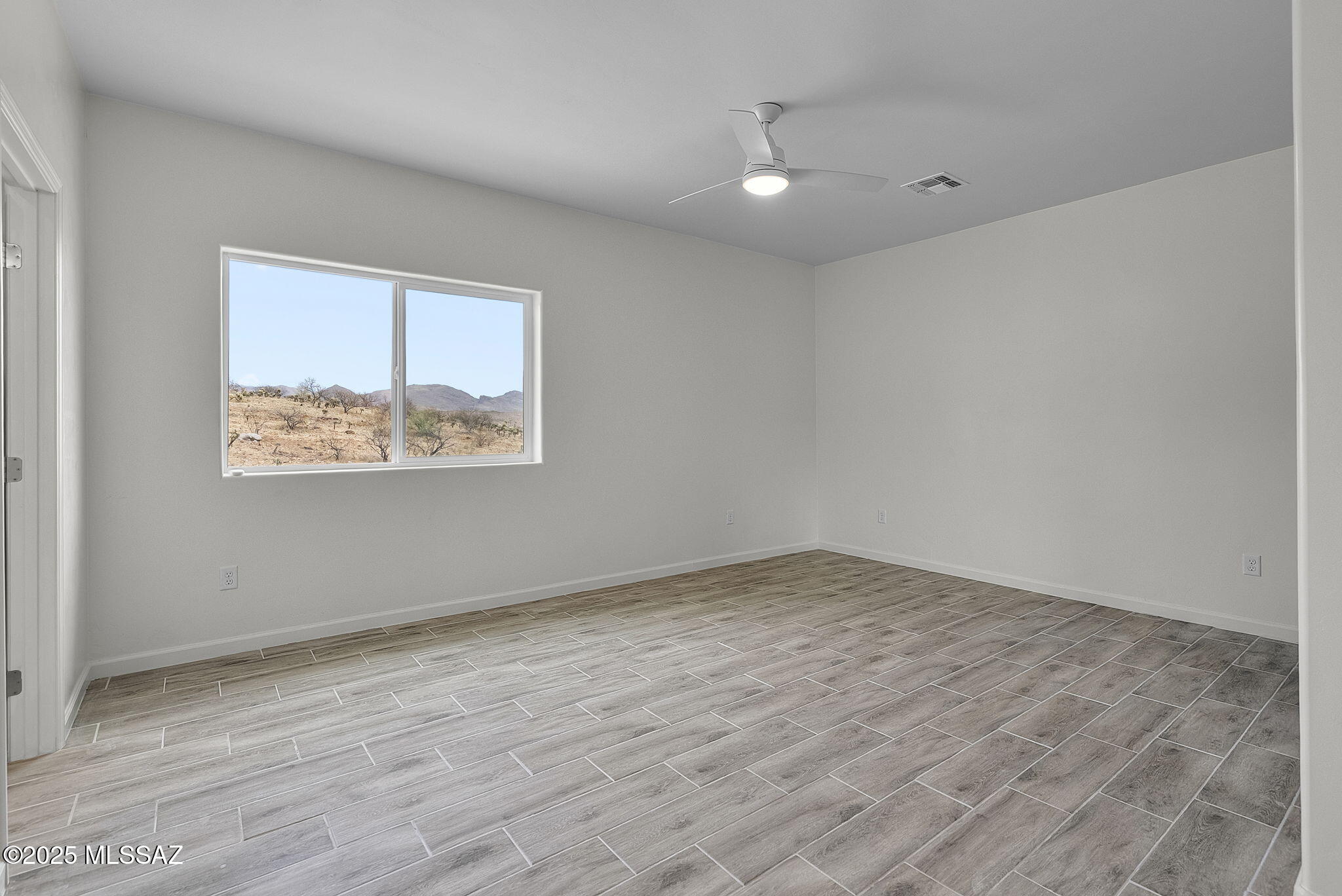 1895 Roma Court Rio Rico, AZ 85648 - Photo 16 of 42 a view of an empty room with wooden floor and a window