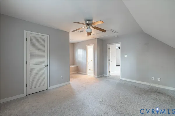 a view of a big room with chandelier fan and windows