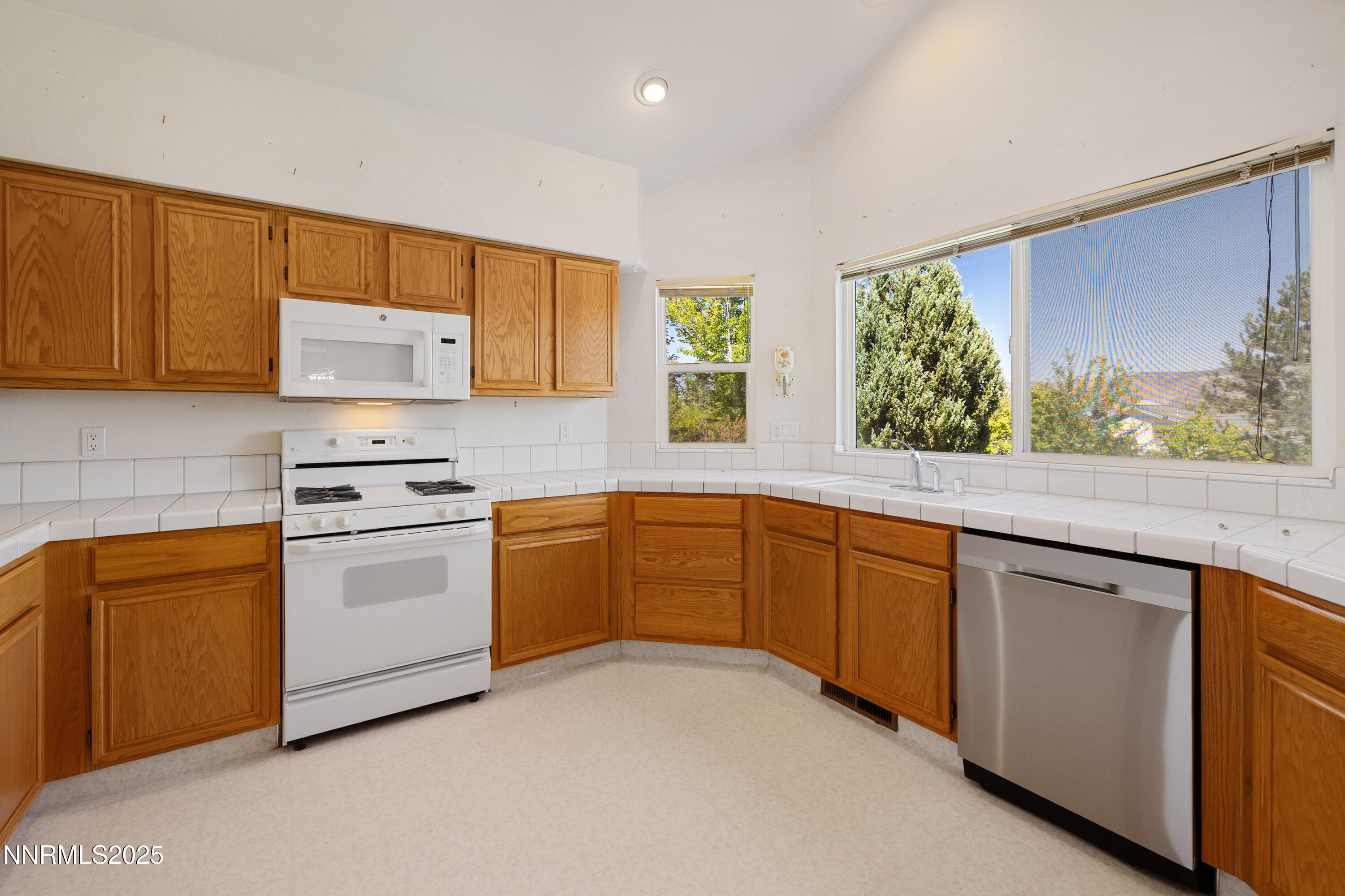 14330 Ghost Rider Drive Reno, NV 89511 - Photo 8 of 41 a kitchen with granite countertop white cabinets and white appliances