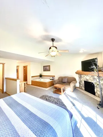 a spacious bedroom with a bed and a flat screen tv