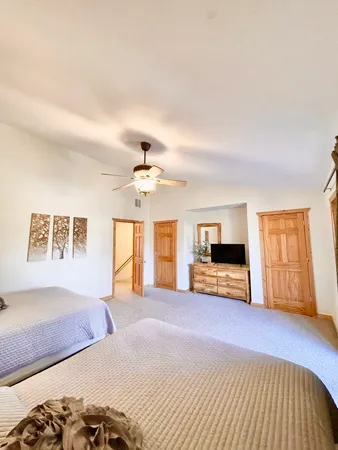 a spacious bedroom with a bed and wooden floor