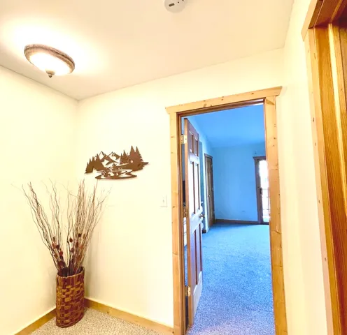 a view of a hallway with a dining table and a chair