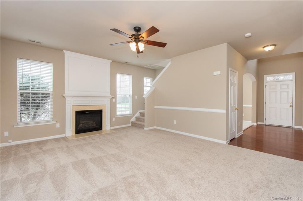 9824 Caldwell Depot Road Cornelius, NC 28031 - Photo 15 of 29 a view of an empty room with chandelier fan and fire place