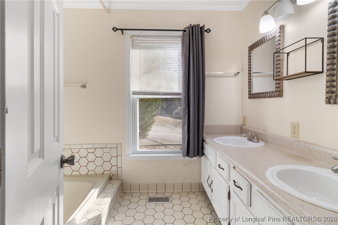 2924 Walden Road Fayetteville, NC 28303 - Photo 24 of 44 a bathroom with a granite countertop sink a mirror and a bathtub