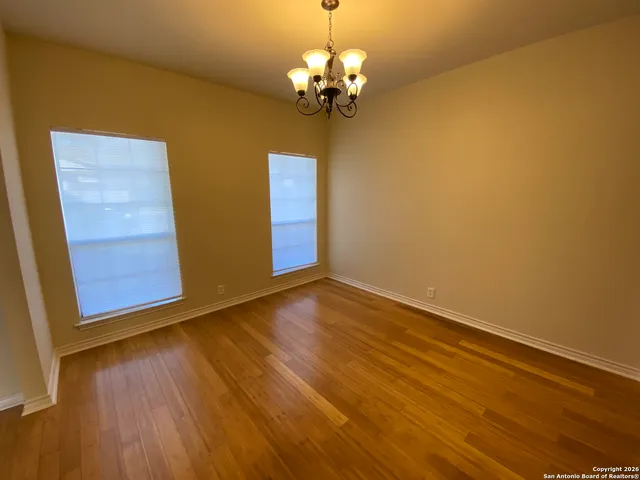 a view of a room with wooden floor and chandelier