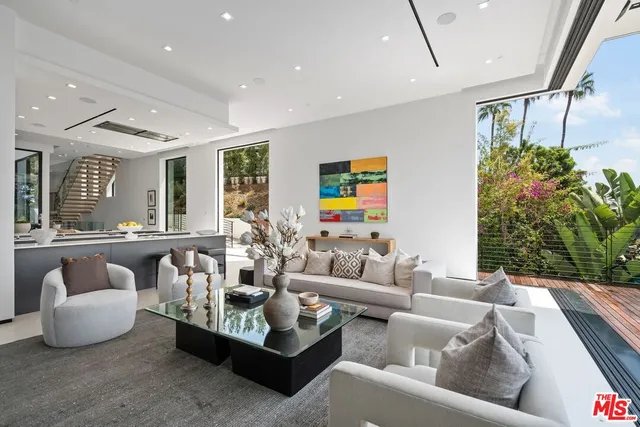 a living room with fireplace furniture and a large window