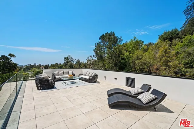 a view of roof deck with couches and wooden floor