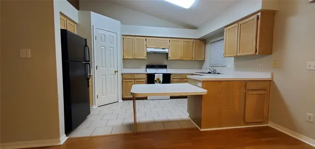 a kitchen with a sink cabinets and wooden floor