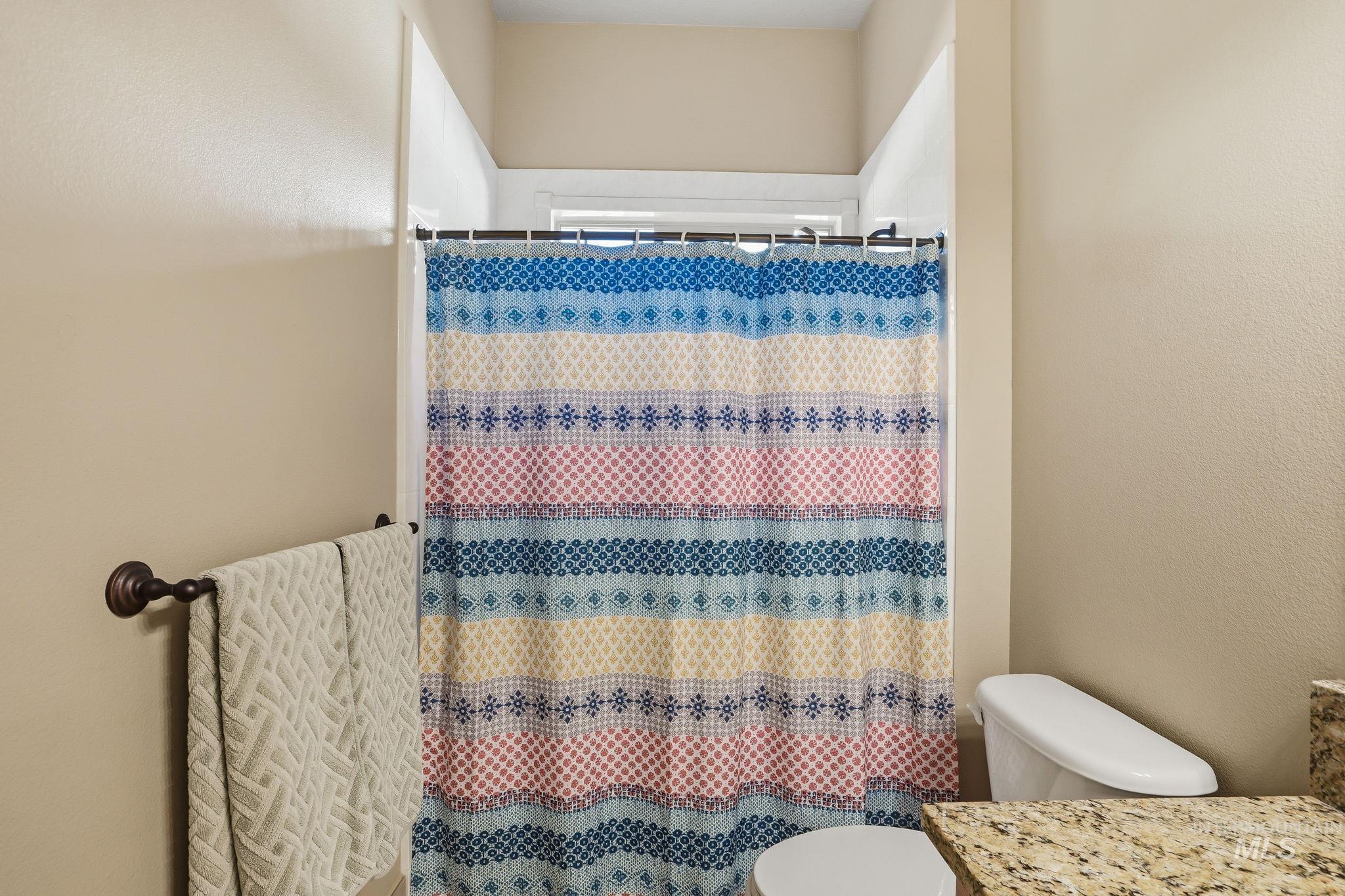 3969 North Hollymount Way Meridian, ID 83646 - Photo 30 of 47 Bathroom featuring a shower with a patterned curtain, a toilet, a vanity with a stone-finish countertop, and a towel bar