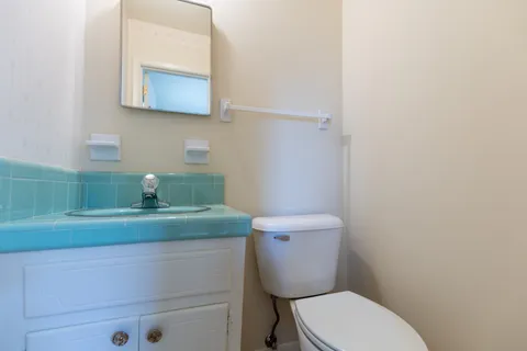 a bathroom with a toilet a sink and mirror