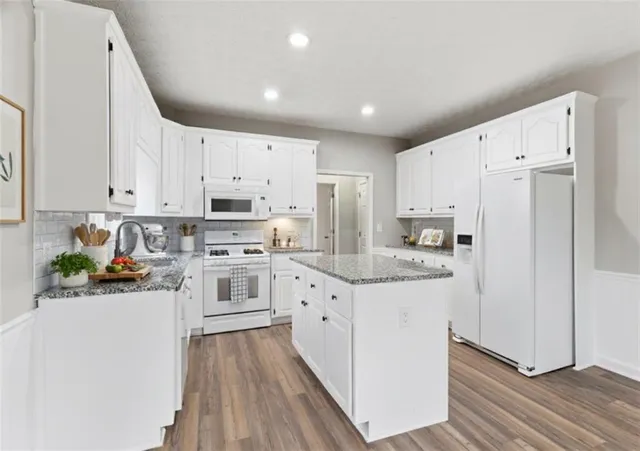 a kitchen with white cabinets and white appliances