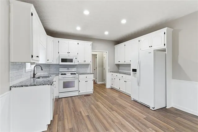 a kitchen with stainless steel appliances white cabinets and a refrigerator