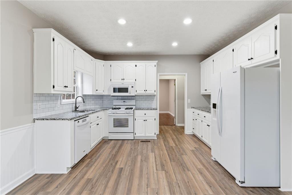 125 Nelson Oaks Drive Ball Ground, GA 30107 - Photo 13 of 41 a large kitchen with stainless steel appliances a refrigerator and white cabinets