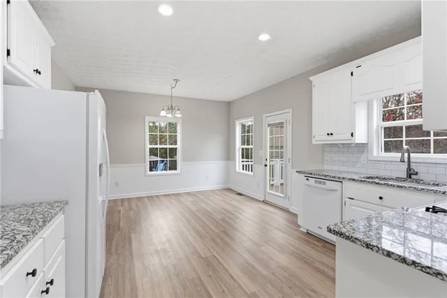 a large kitchen with granite countertop a window and wooden floor