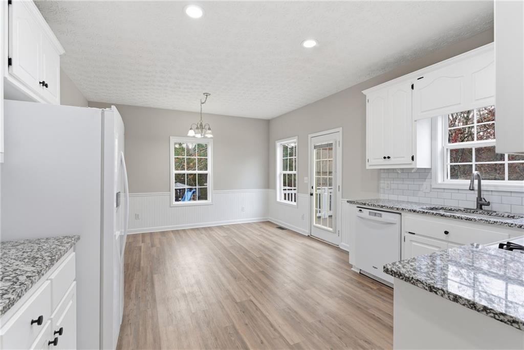 125 Nelson Oaks Drive Ball Ground, GA 30107 - Photo 14 of 41 a large kitchen with granite countertop a window and wooden floor