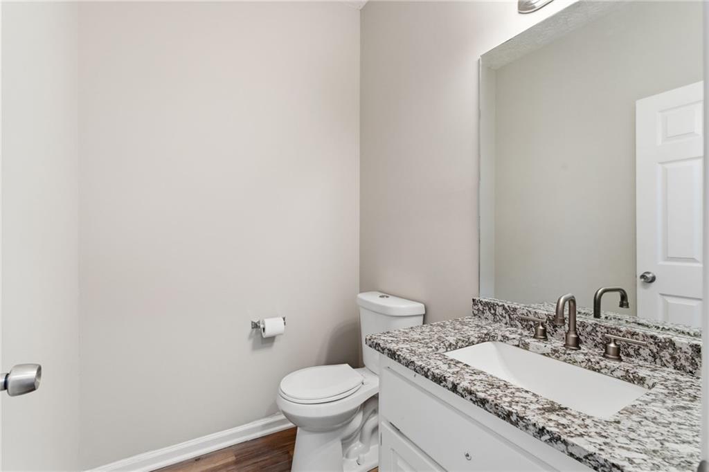 125 Nelson Oaks Drive Ball Ground, GA 30107 - Photo 19 of 41 a bathroom with a granite countertop sink mirror vanity and toilet