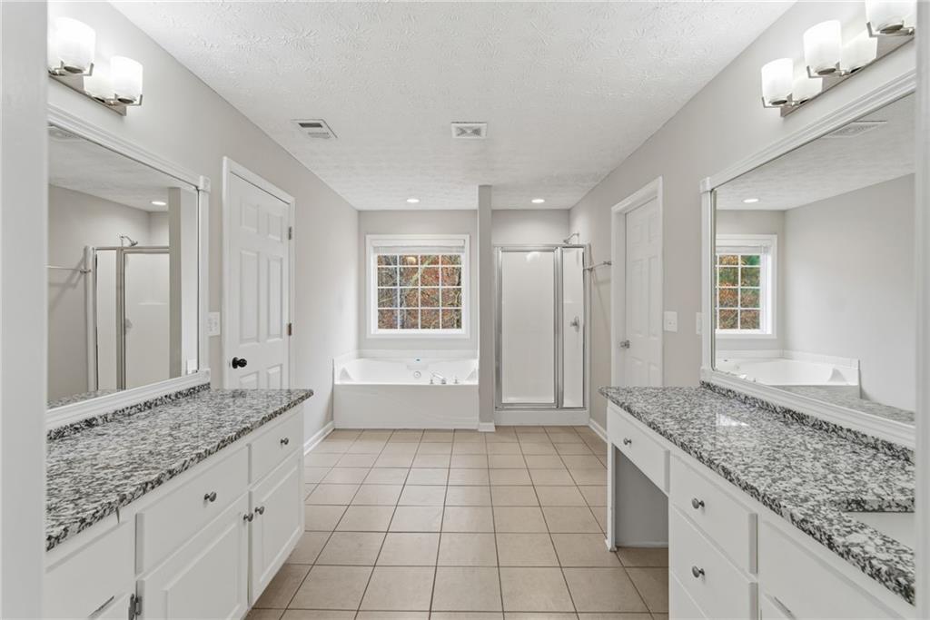 125 Nelson Oaks Drive Ball Ground, GA 30107 - Photo 24 of 41 a bathroom with a granite countertop sink a toilet and a bathtub