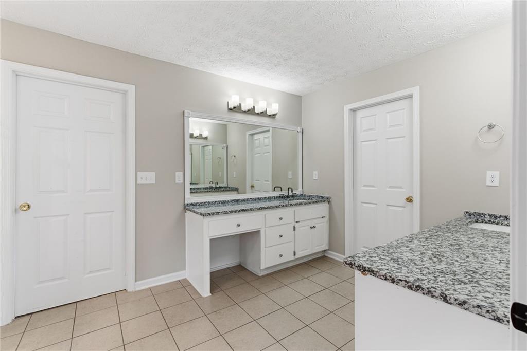 125 Nelson Oaks Drive Ball Ground, GA 30107 - Photo 25 of 41 a spacious bathroom with a granite countertop sink and a mirror