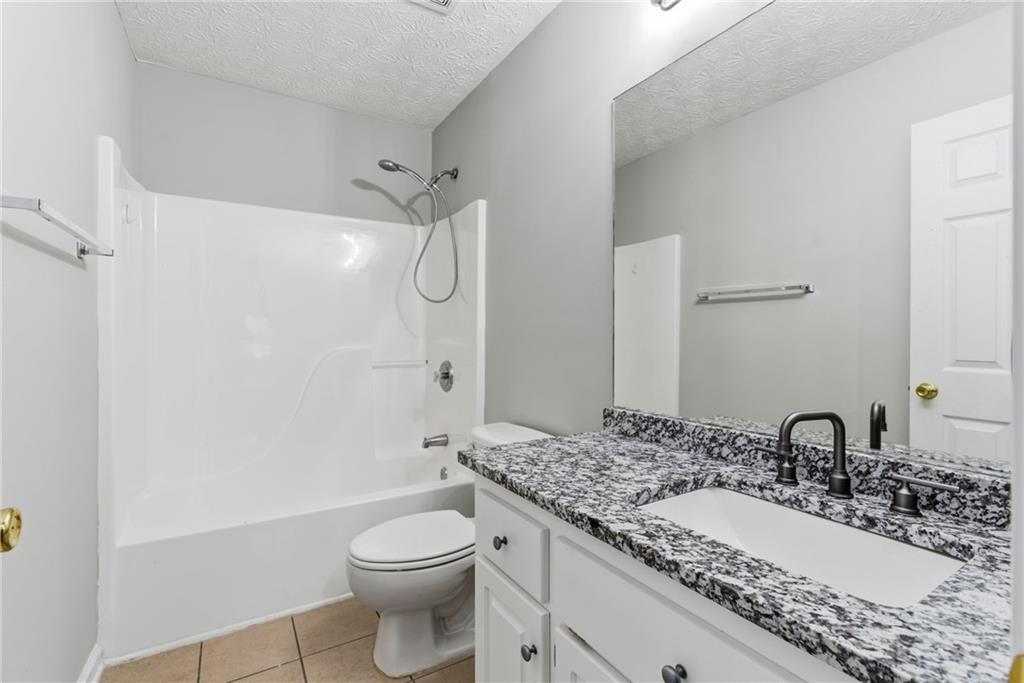 125 Nelson Oaks Drive Ball Ground, GA 30107 - Photo 29 of 41 a bathroom with a granite countertop sink toilet and shower