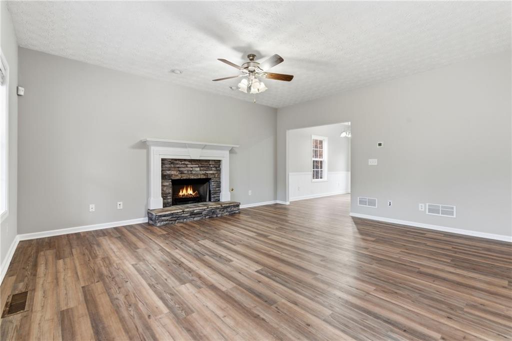 125 Nelson Oaks Drive Ball Ground, GA 30107 - Photo 3 of 41 a view of an empty room with wooden floor and a fireplace