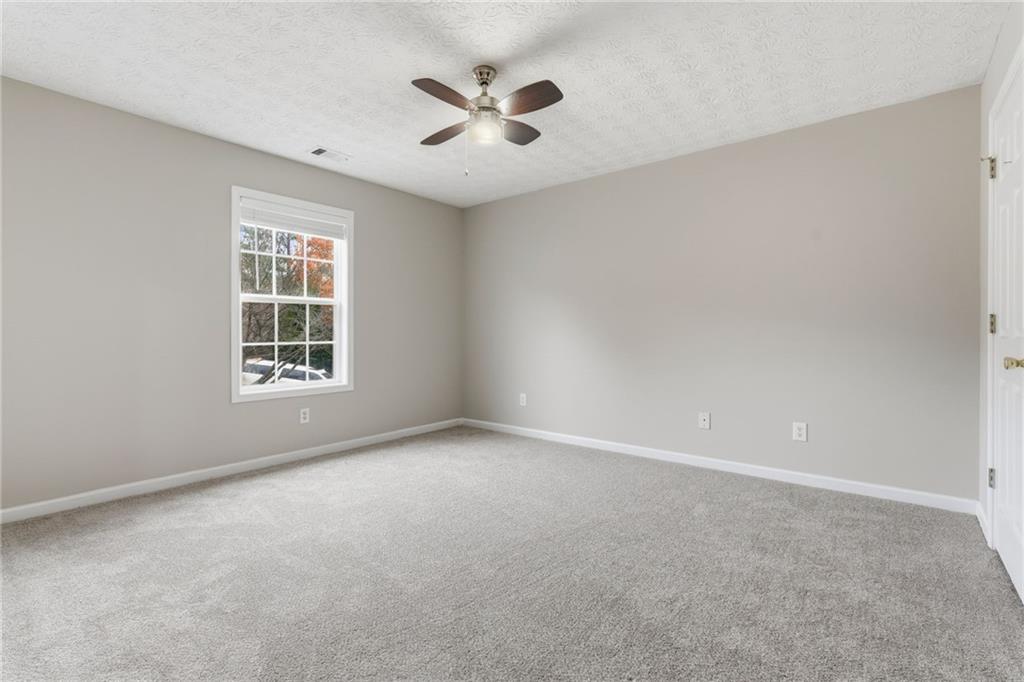 125 Nelson Oaks Drive Ball Ground, GA 30107 - Photo 31 of 41 an empty room with windows and ceiling fan