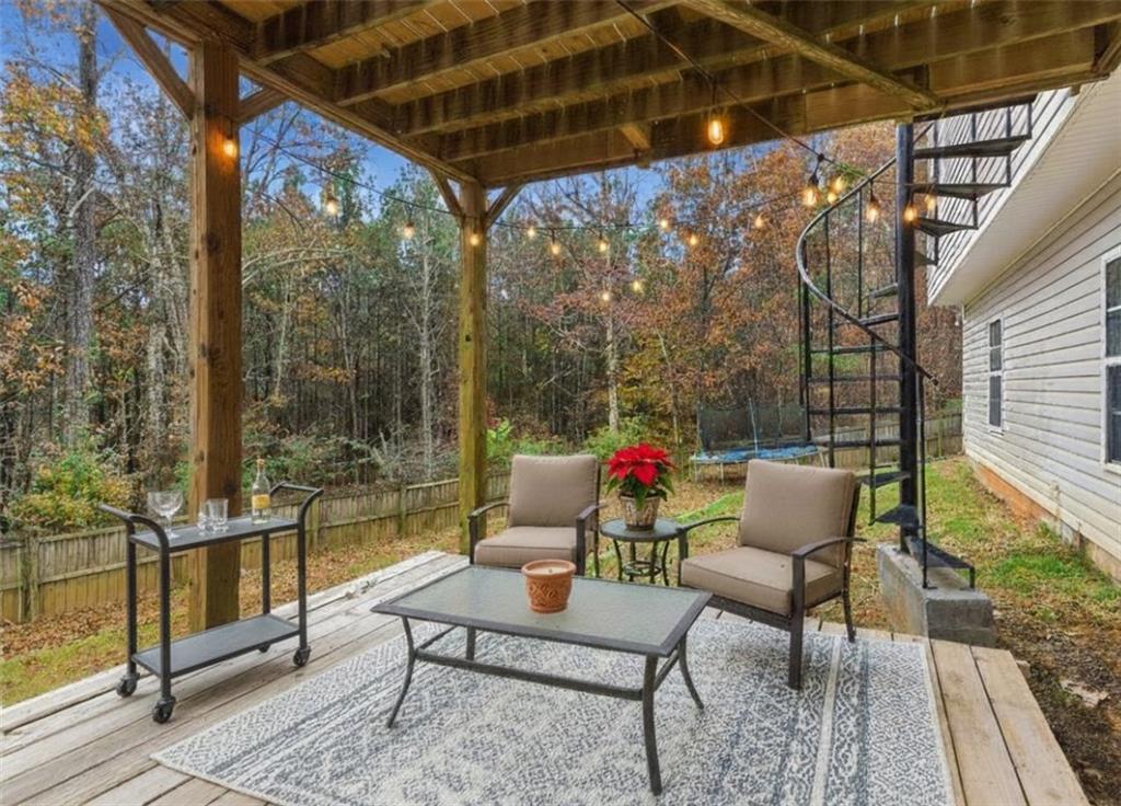 125 Nelson Oaks Drive Ball Ground, GA 30107 - Photo 36 of 41 a outdoor sitting area with couch and wooden floor