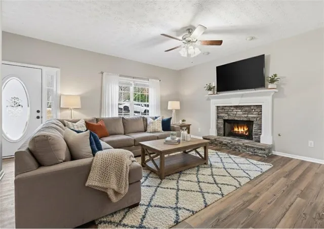 a living room with furniture a flat screen tv and a fireplace