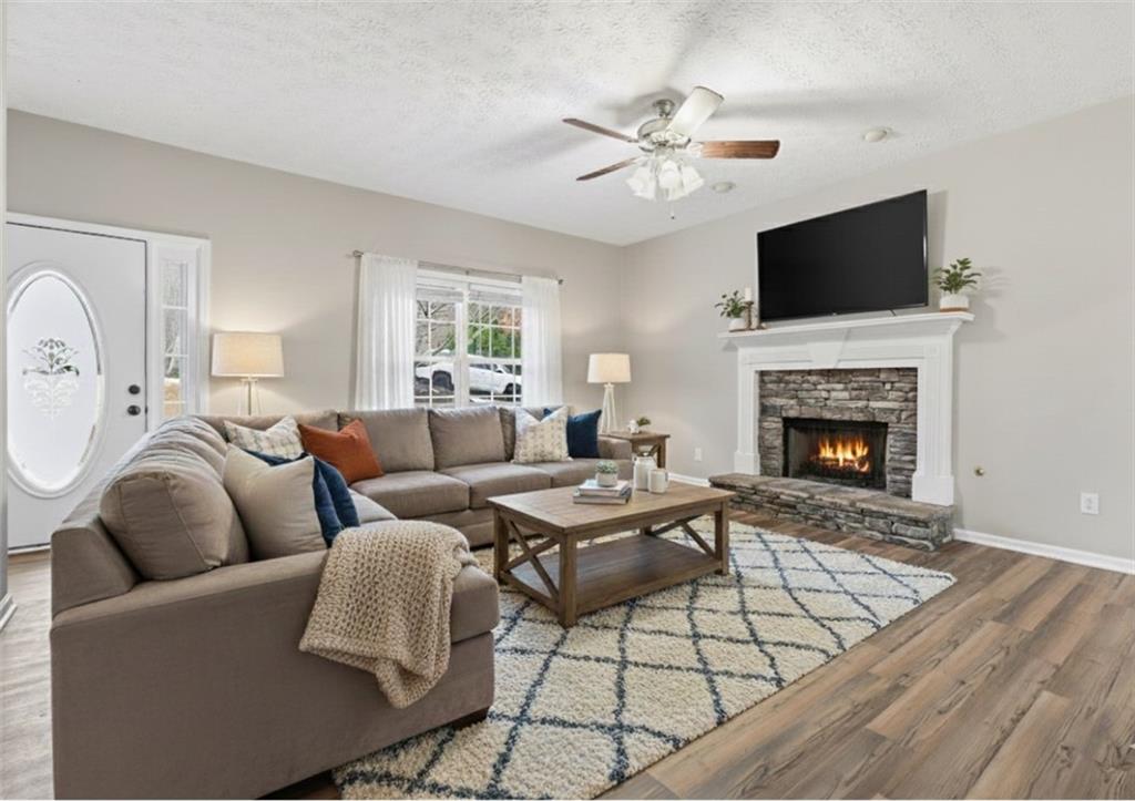 125 Nelson Oaks Drive Ball Ground, GA 30107 - Photo 4 of 41 a living room with furniture a flat screen tv and a fireplace