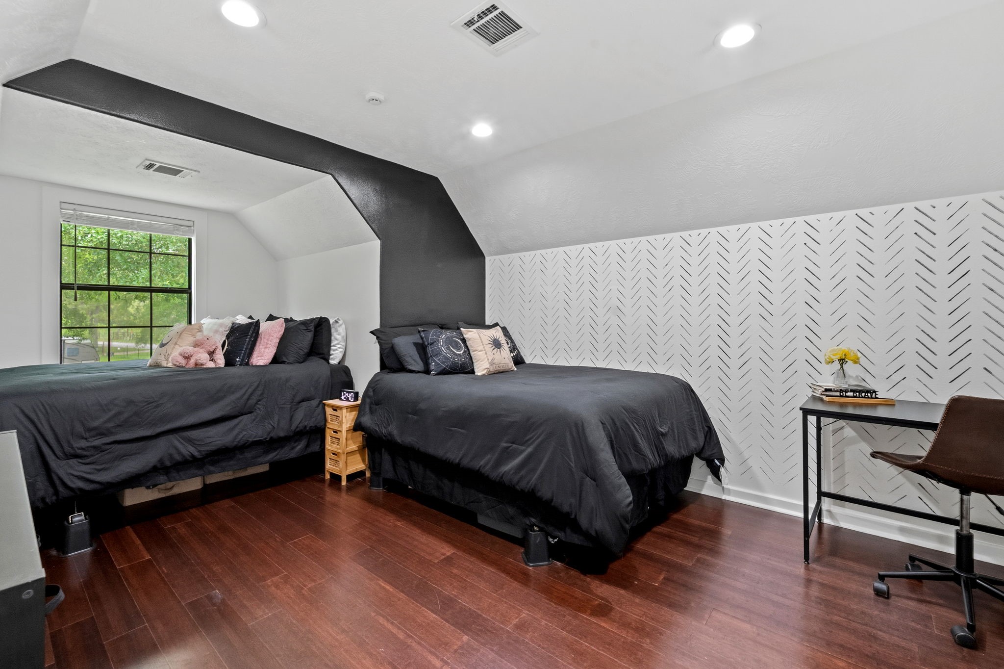 18 East Old Field Road Huffman, TX 77336 - Photo 22 of 35 Spacious secondary bedroom featuring rich wood flooring, high ceilings, custom accent walls, & abundant natural light that creates a comfortable and inviting retreat.
