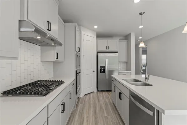 a kitchen with stainless steel appliances a sink stove and refrigerator