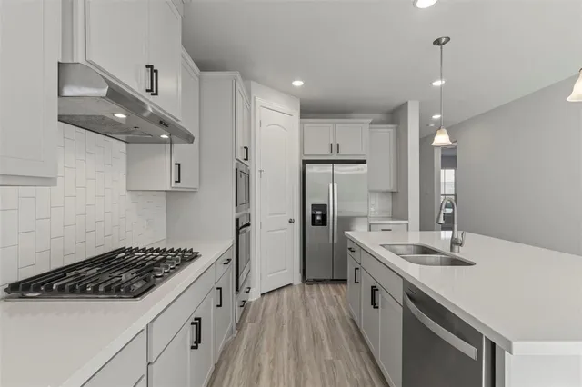 a kitchen with stainless steel appliances a sink stove and refrigerator