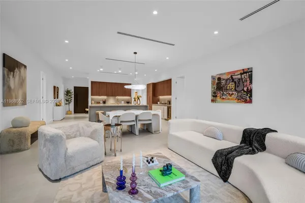 a living room with furniture and view of kitchen