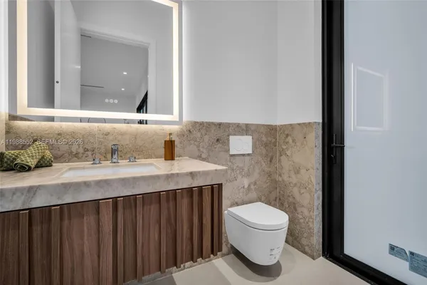 a bathroom with a granite countertop sink toilet a mirror and shower