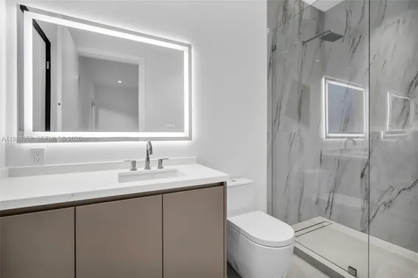 a bathroom with a granite countertop sink toilet and shower