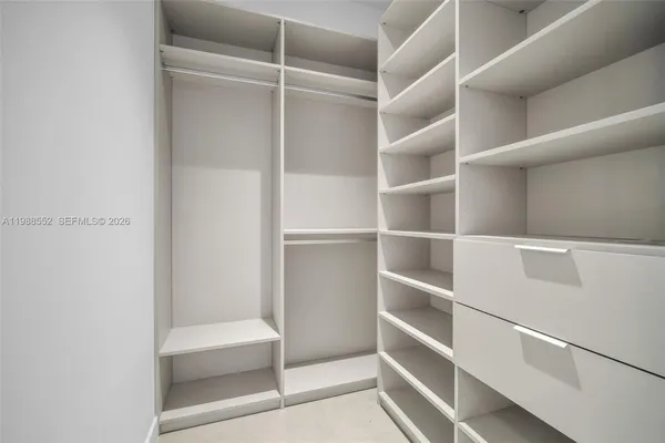 a view of walk in closet with empty racks