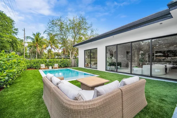 a view of a house with a swimming pool and a yard