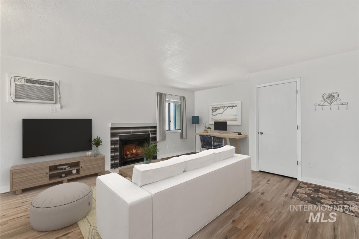 7084 West Colehaven Lane Boise, ID 83704 - Photo 7 of 23 Living room featuring a fireplace, wood finished floors, and an AC wall unit