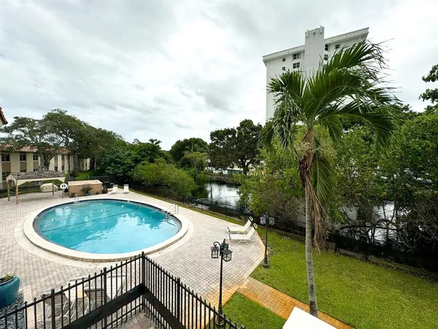 a view of a swimming pool with a yard and sitting area