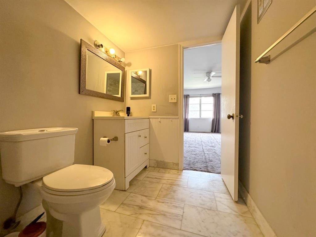 12 Northeast 19th Court, Unit 204A Wilton Manors, FL 33305 - Photo 6 of 21 a bathroom with a sink a toilet and shower