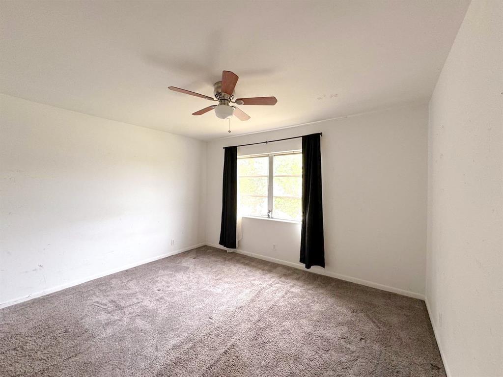 12 Northeast 19th Court, Unit 204A Wilton Manors, FL 33305 - Photo 10 of 21 an empty room with a window and a fan