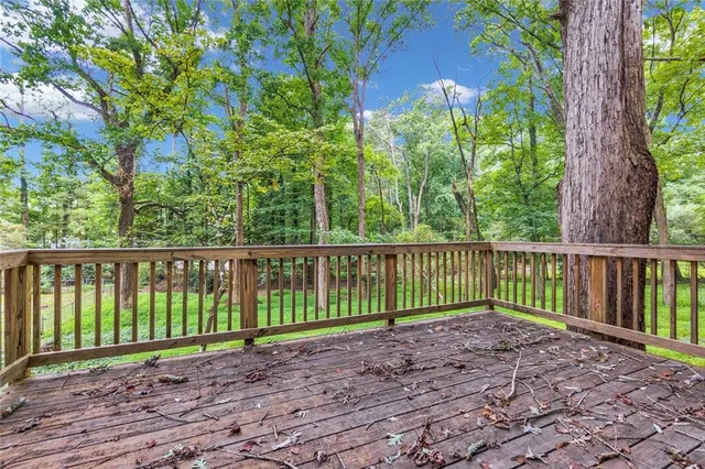 a view of a house with a yard and large tree