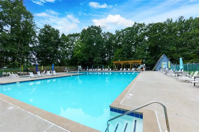 a view of the patio with couches and table and chairs with wooden fence and plants